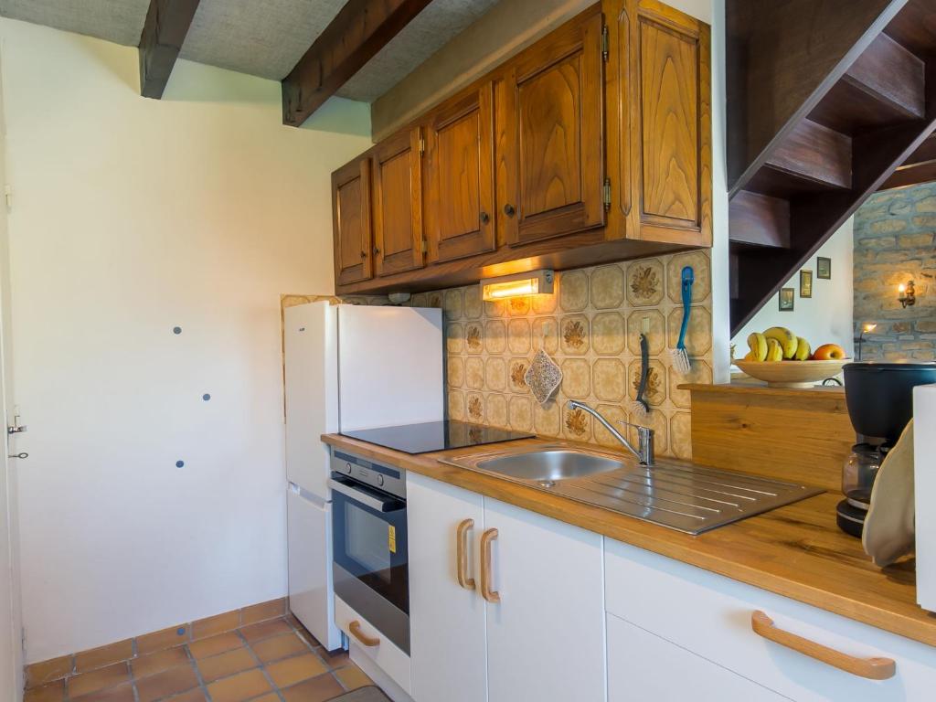 a kitchen with a white refrigerator and a sink at Holiday Home Blaue Hortensie - SZN100 by Interhome in Sizun
