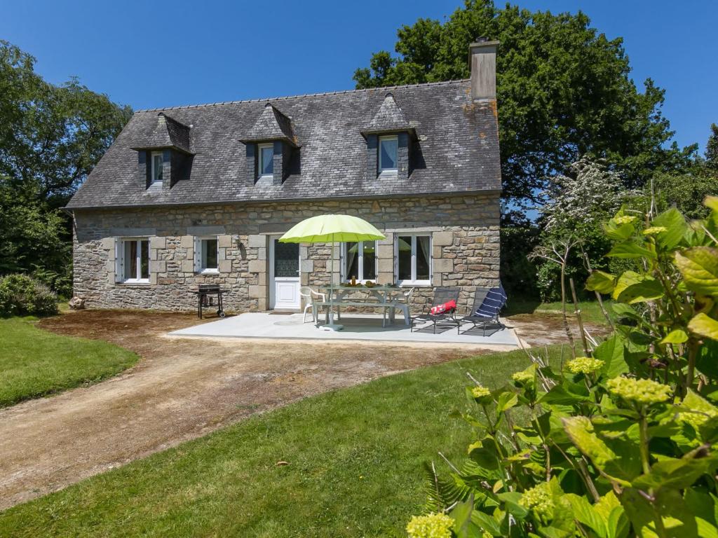 a stone house with a table and chairs in front of it at Holiday Home Blaue Hortensie - SZN100 by Interhome in Sizun