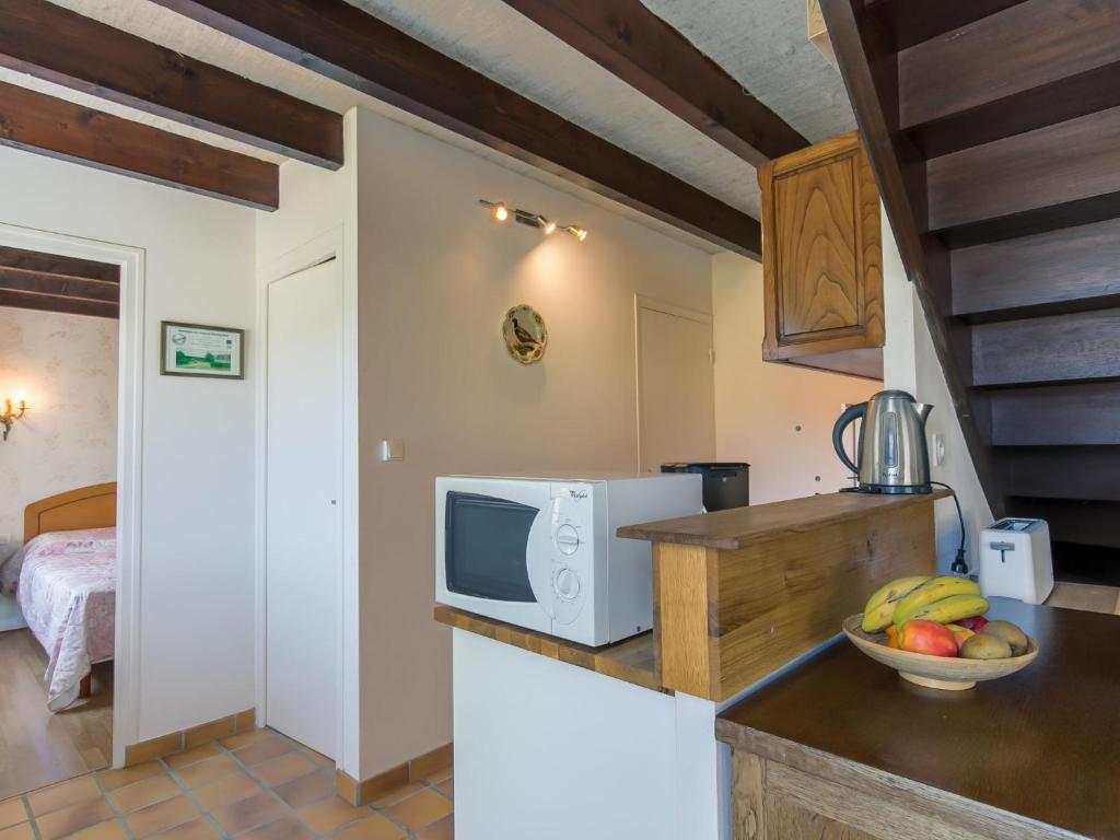 a kitchen with a microwave and a bowl of fruit on a counter at Holiday Home Blaue Hortensie - SZN100 by Interhome in Sizun