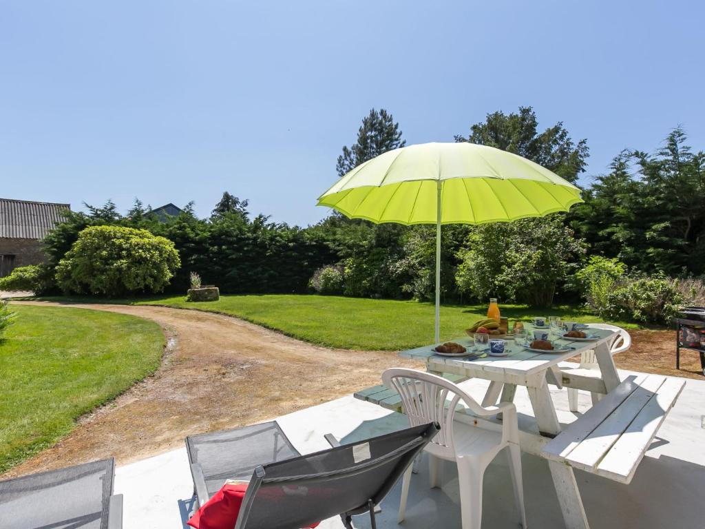 a table and chairs with a yellow umbrella at Holiday Home Blaue Hortensie - SZN100 by Interhome in Sizun
