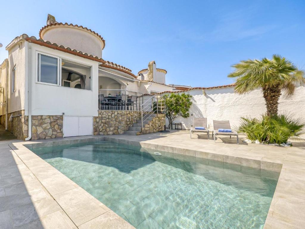 a swimming pool in front of a house at Holiday Home Sunset by Interhome in Empuriabrava