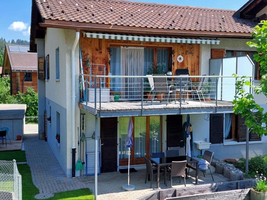 Cette maison dispose d'un balcon avec une table et des chaises. dans l'établissement Apartment Daheim by Interhome, à Zweisimmen