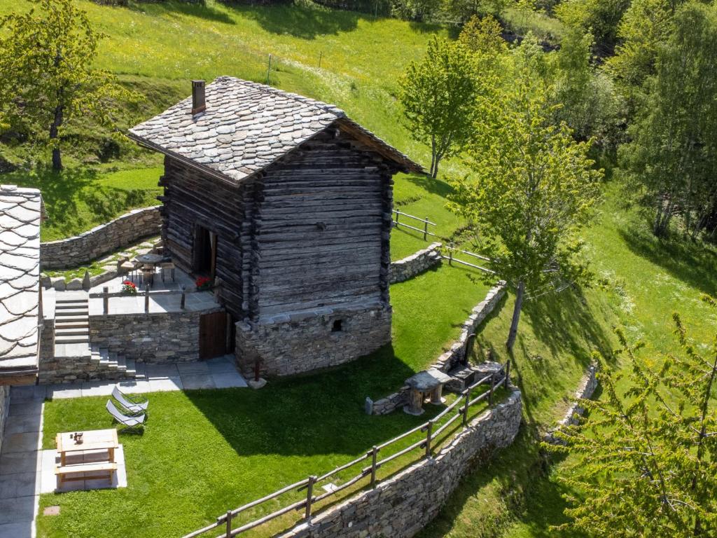 un vecchio edificio in un campo con una recinzione di Chalet Chalet les Combes by Interhome a Introd