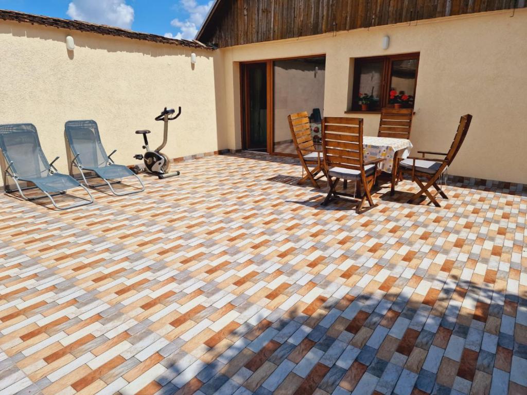 a patio with a table and chairs on a checkered floor at Studio minunat de vacanta Cristian in Cristian