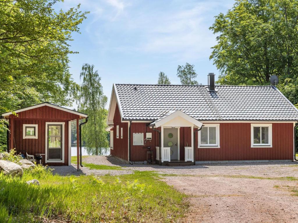 a red house with a garage at Holiday Home Erikstorp Femman - B in Olofström