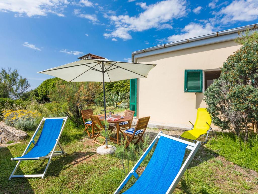 patio con tavolo, sedie e ombrellone di Holiday Home Il Giardino sul Mare by Interhome a Castiglioncello