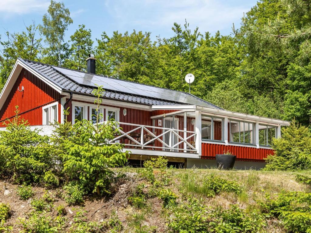 uma casa vermelha com um telhado preto em Holiday Home Erikstorp Trean by Interhome em Olofström