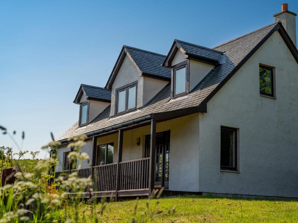 a large white house with a gambrel roof at Holiday Home Ceilidhtail Cottage by Interhome in Drumnadrochit