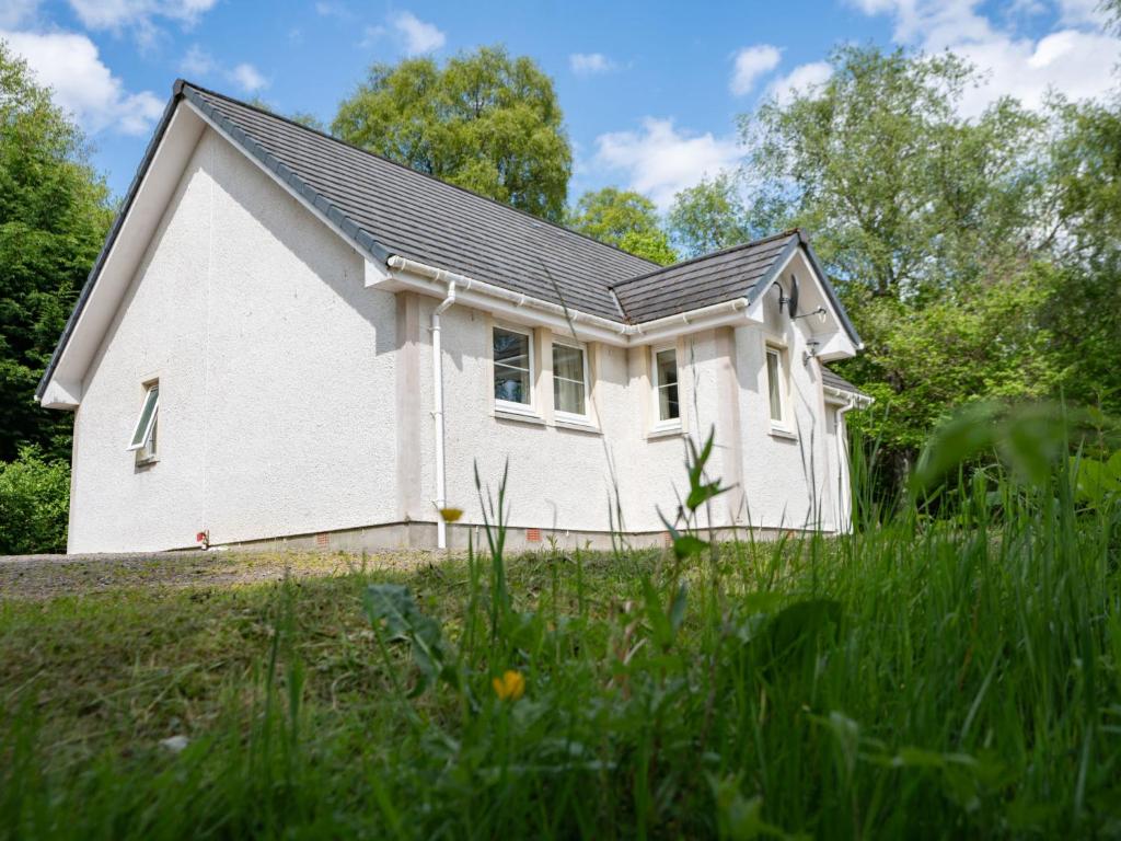 a white house with a black roof at Holiday Home Silver Birch by Interhome in Drumnadrochit