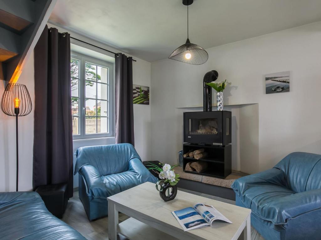 ein Wohnzimmer mit 2 blauen Stühlen und einem Kamin in der Unterkunft Holiday Home Le Coup de Coeur by Interhome in Locquirec