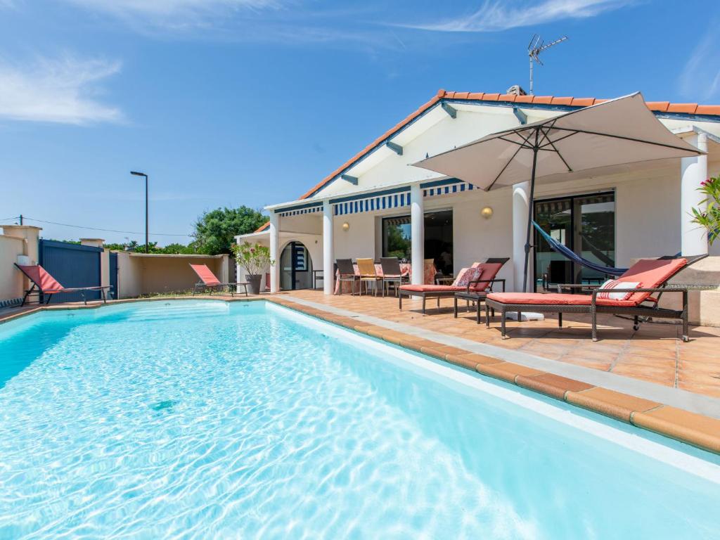 a swimming pool in front of a house at Holiday Home Corsaires by Interhome in Vieux-Boucau-les-Bains