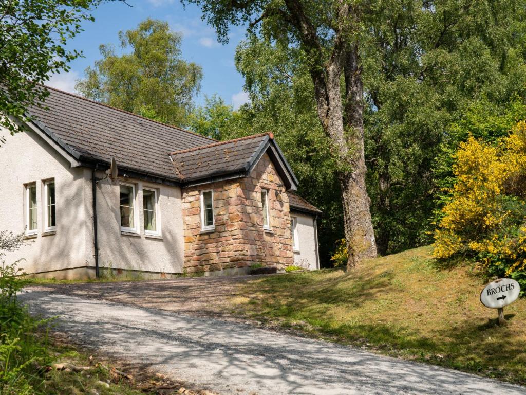 una casa de piedra con una carretera delante de ella en Holiday Home Brocks by Interhome, en Drumnadrochit