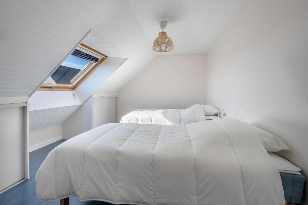 a white bedroom with a white bed and a window at Parenthese relaxante les pieds dans l eau in Le Tour-du-Parc