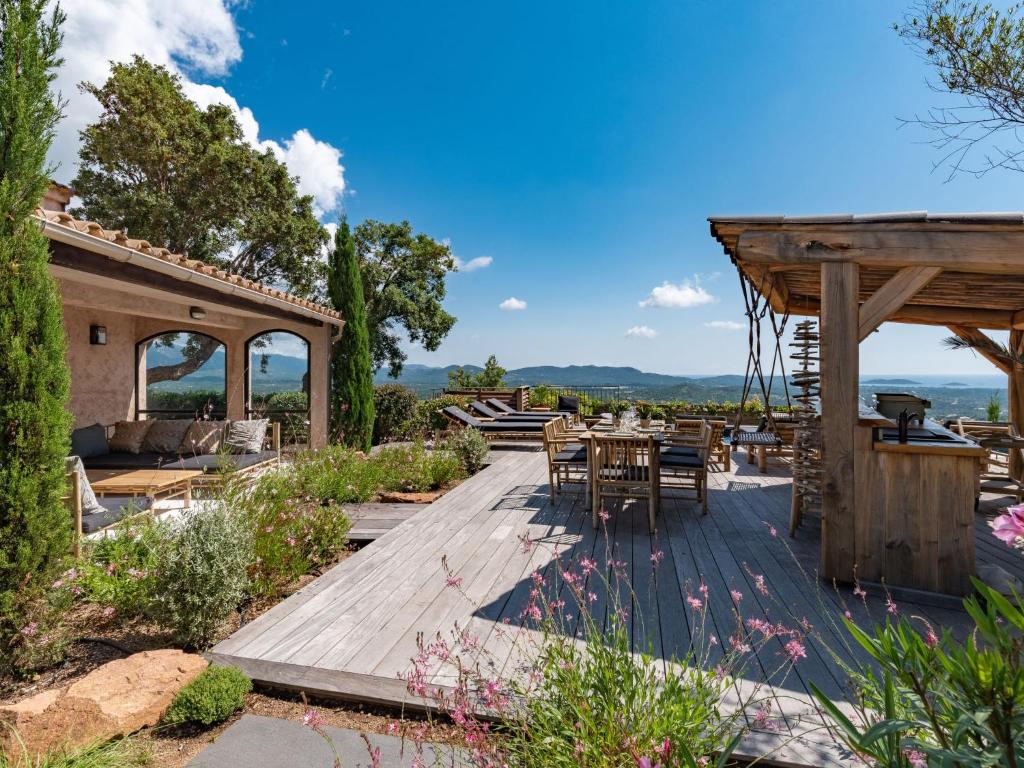 une terrasse en bois avec une table et des chaises. dans l'établissement Villa Villa Casaben by Interhome, à Porto-Vecchio