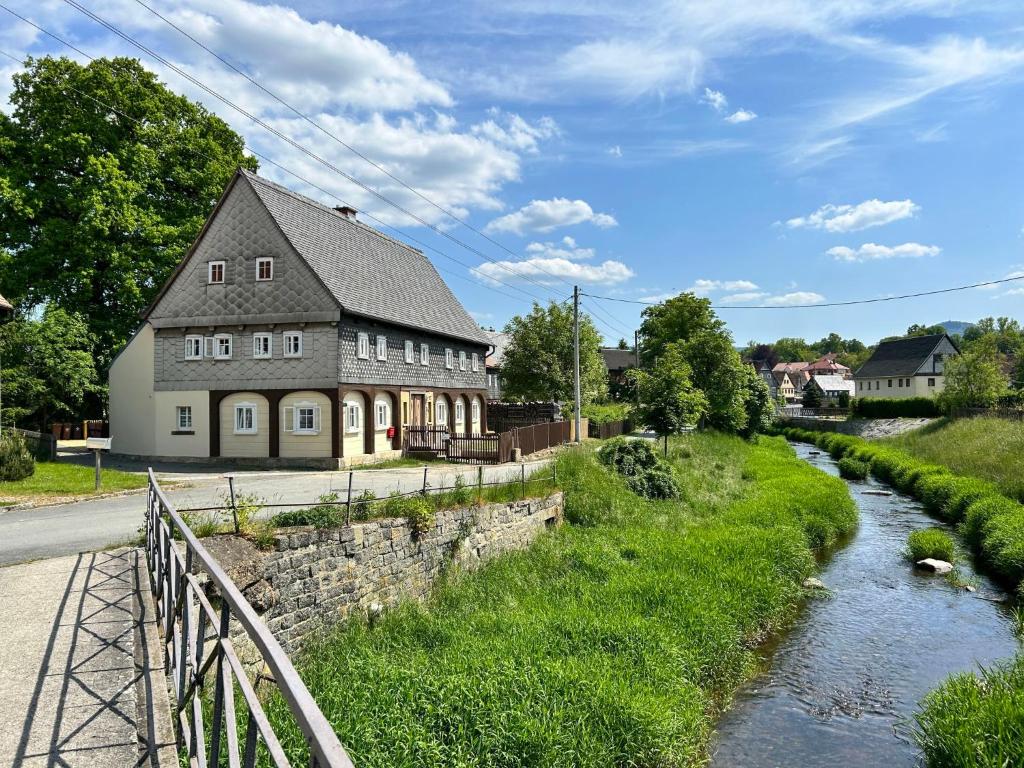 un edificio junto a un río con una casa en Apartment Frushi by Interhome, en Großschönau