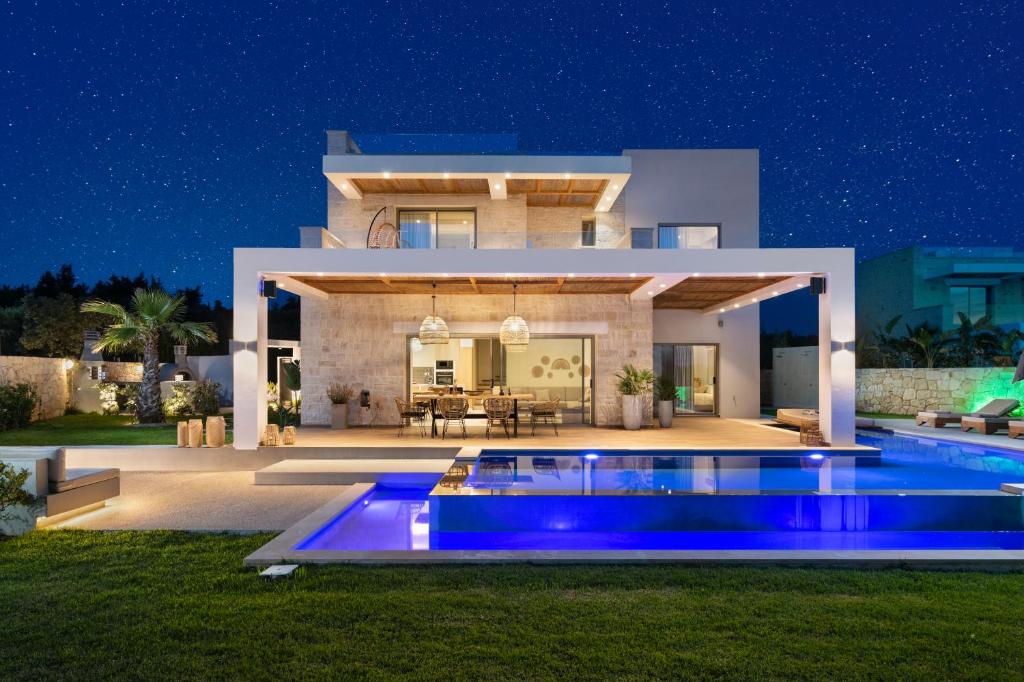 a villa with a swimming pool at night at Sohora twin Villas in Xirostérnion