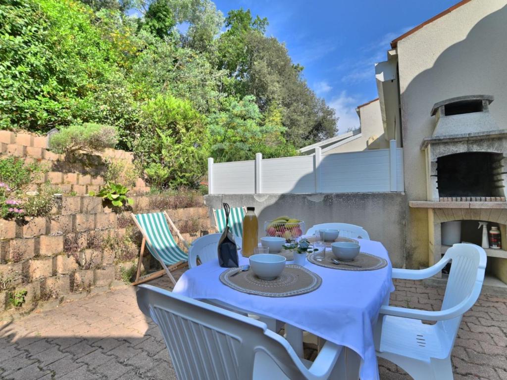 une table et des chaises bleues sur une terrasse dans l'établissement Holiday Home Le Clos de la Forêt by Interhome, à Dolus-d'Oléron