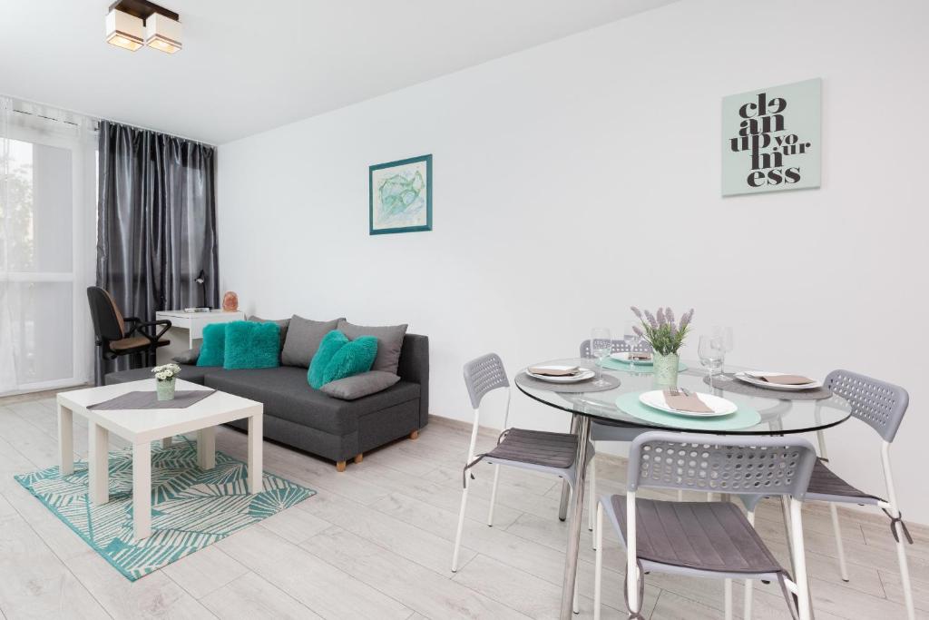 a living room with a table and a couch at Turzycowa Apartment in Gdansk by Renters in Gdańsk