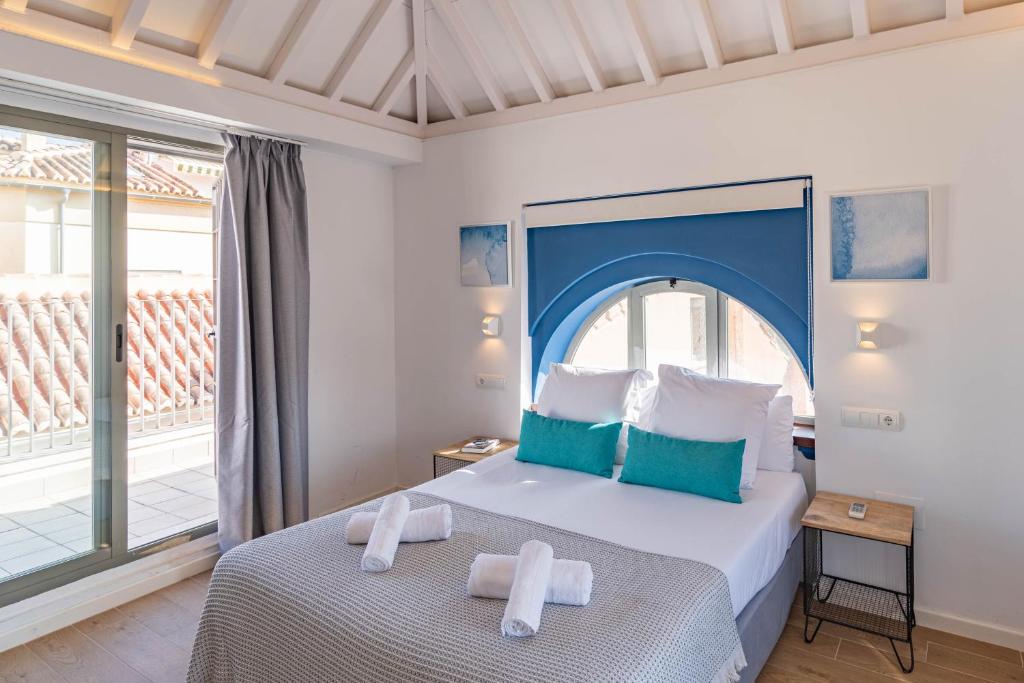 a bedroom with a large bed with towels on it at Feelathome Merced Apartments in Málaga