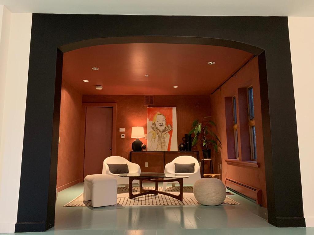 a living room with white chairs and a table at The Trail in Adams - Berkshires' Art Hotel in Adams