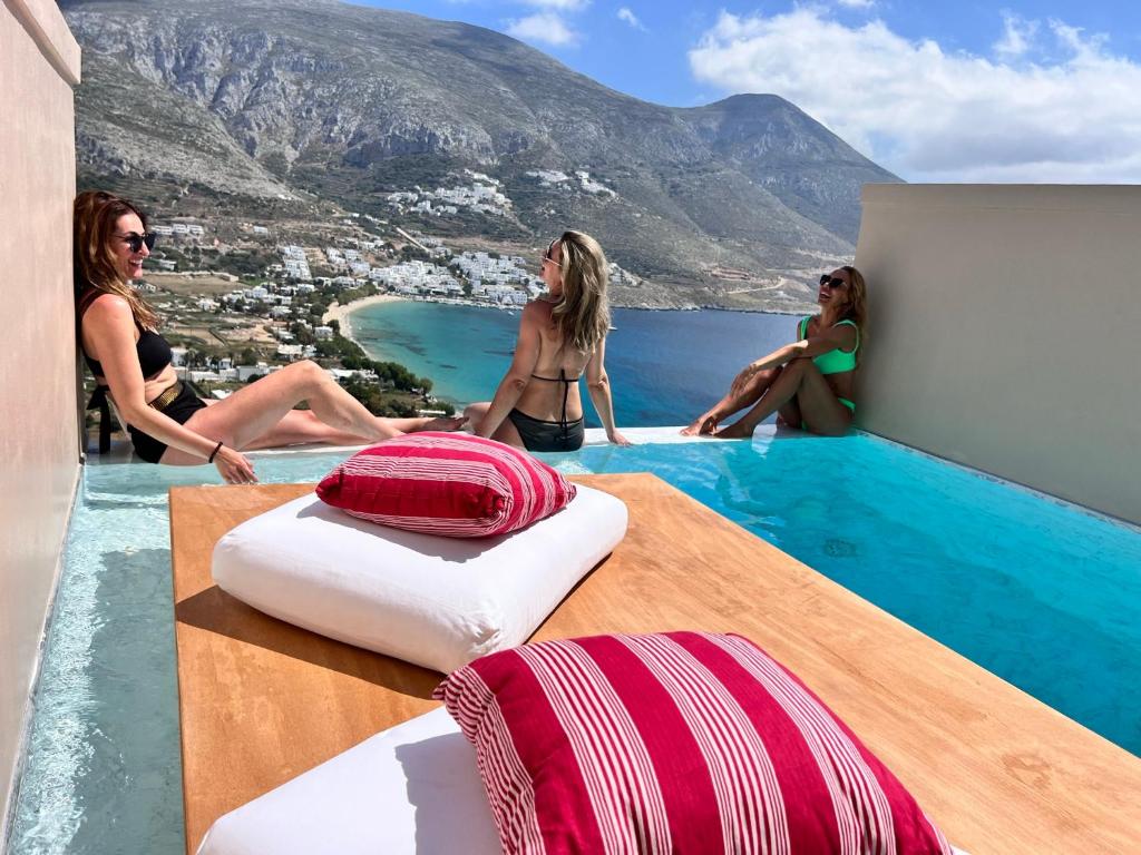 un grupo de mujeres sentadas en el borde de una piscina en Aegialis Hotel & Spa en Aegiali