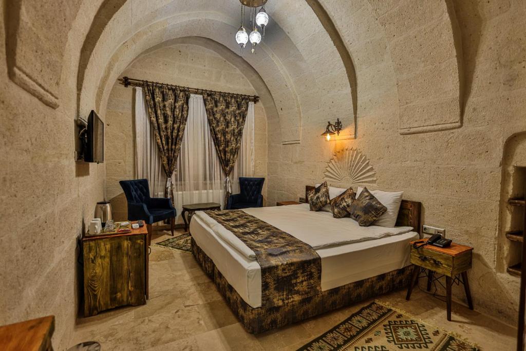 um quarto com uma cama king-size num quarto de pedra em CaveAdocia em Nevşehir