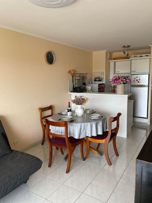 un salon avec une table et des chaises et une cuisine dans l'établissement - Le Montauban - Appartement avec grande terrasse, à La Chaume