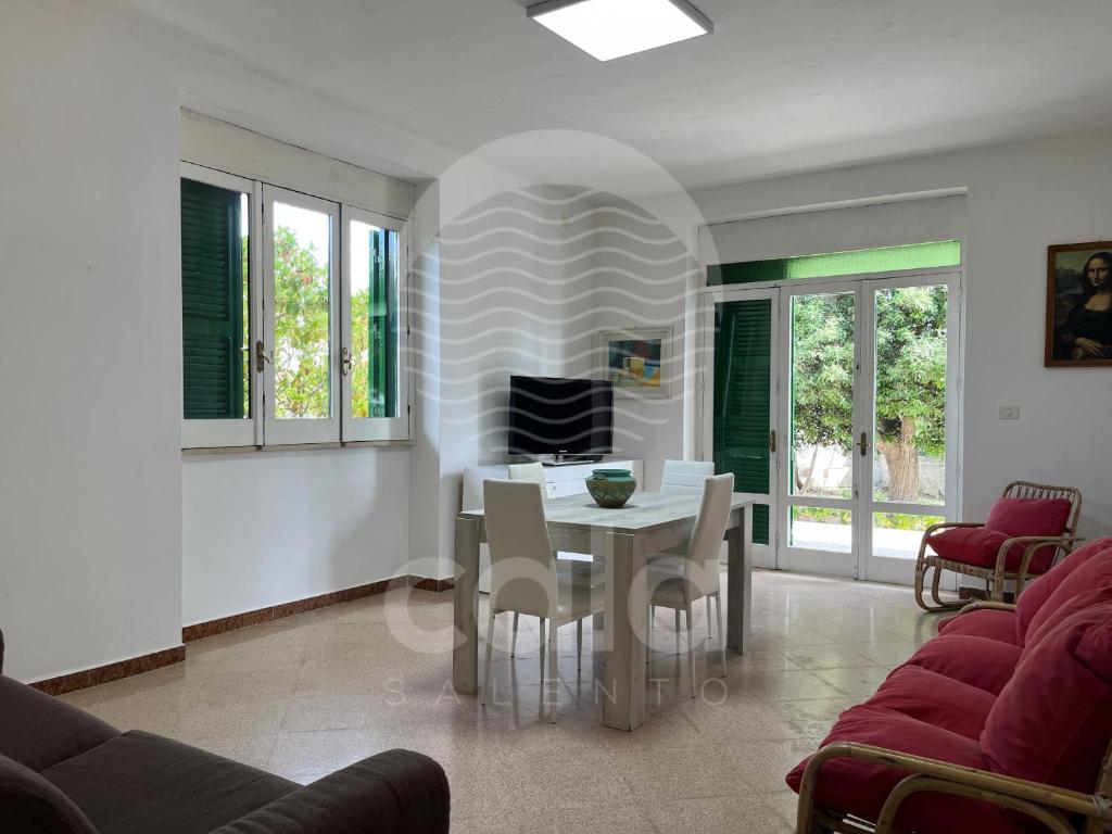 a living room with a white table and chairs at Villetta Trama- Spiaggia a 100m in Porto Cesareo
