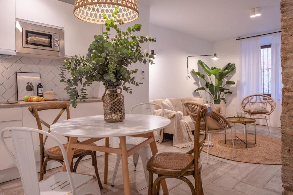 uma cozinha e sala de estar com mesa e cadeiras em apartamentos junto a jardines del triunfo em Granada
