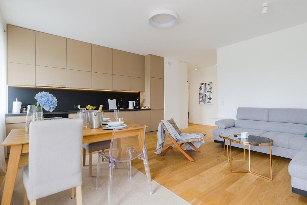 uma sala de estar com uma mesa e um sofá em Woronicza Premium Apartments - 80 em Varósvia