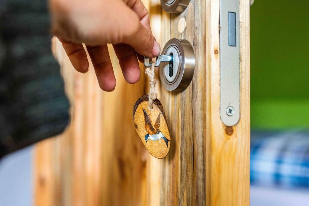 a person unlocking a wooden door with a dog key at Schwalbenwohnung 