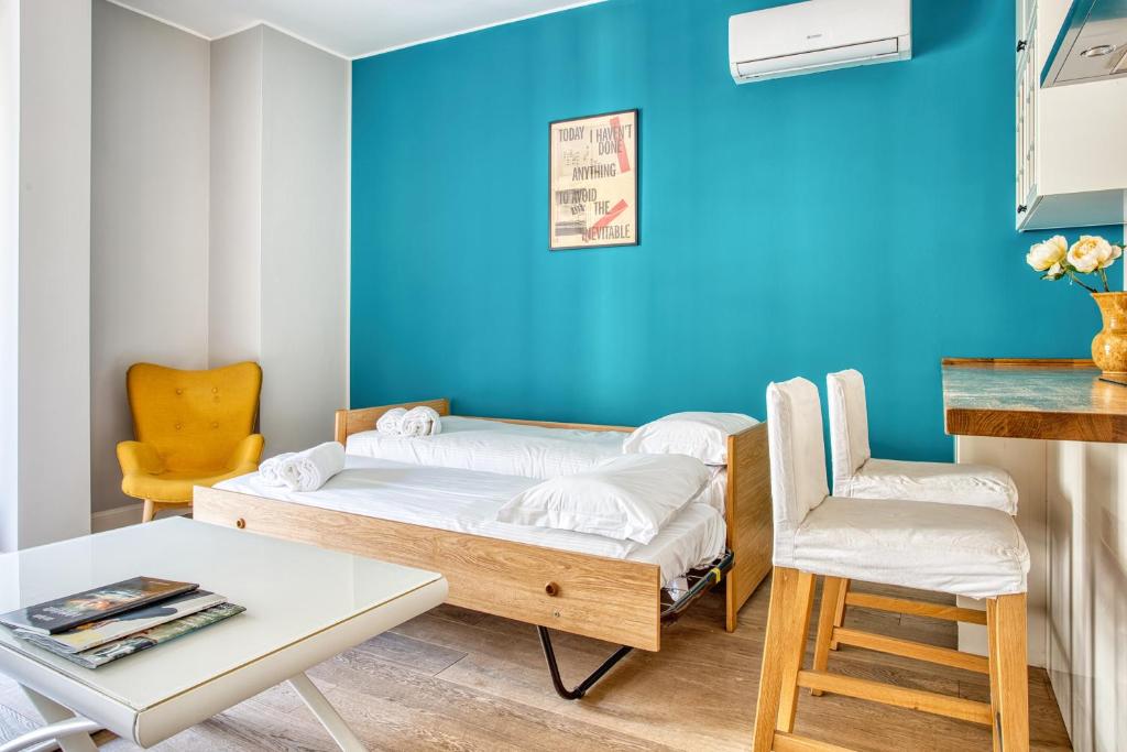 a room with two beds and a table and a chair at ALTIDO Delightful flat with terrace in Milan