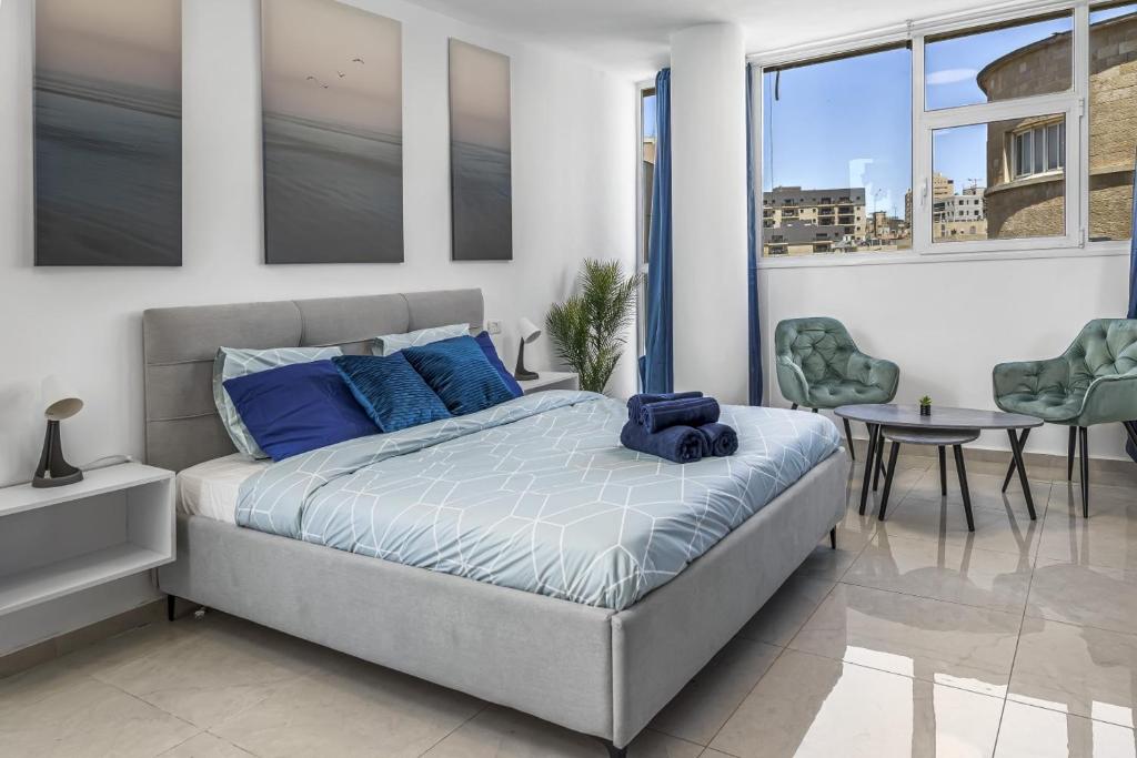 um quarto com uma cama, uma mesa e cadeiras em IB Properties Suites em Jerusalém