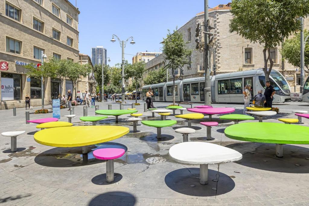 um grupo de mesas numa rua com um comboio em IB Properties Suites em Jerusalém