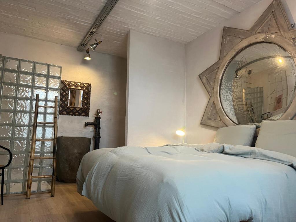 ein Schlafzimmer mit einem großen weißen Bett und einem Spiegel in der Unterkunft Loft by Conceptliving in Kortrijk