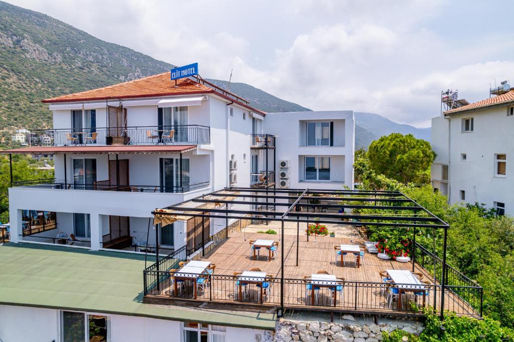 ein Gebäude mit einem Balkon mit Tischen und Stühlen in der Unterkunft Elit Hotel Kas in Kaş