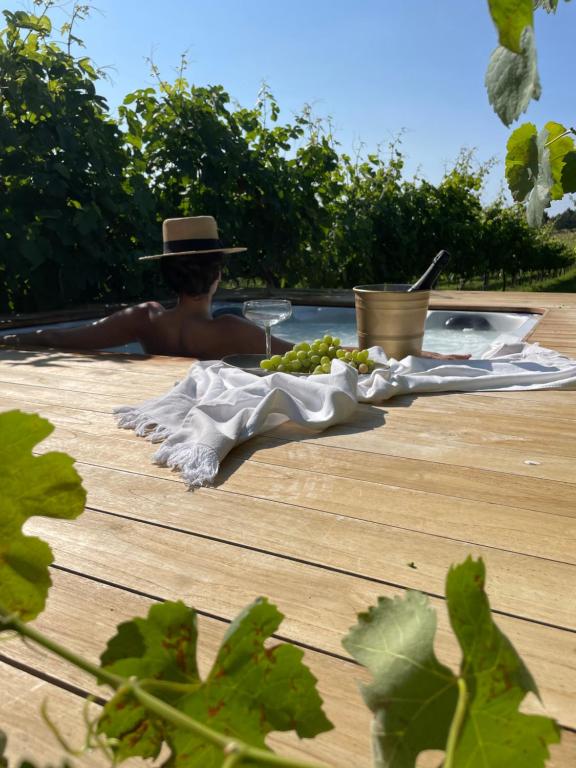 um homem de chapéu sentado à mesa com uvas em Vinha by NHôme em Ponte de Lima