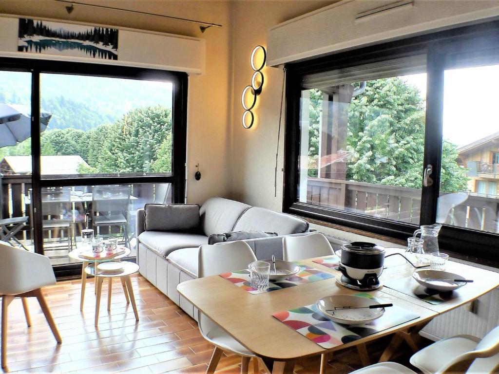 un salon avec un canapé et une table dans l'établissement Charmant duplex au centre de Samoëns avec balcon, WiFi et parking - FR-1-629-115, à Samoëns