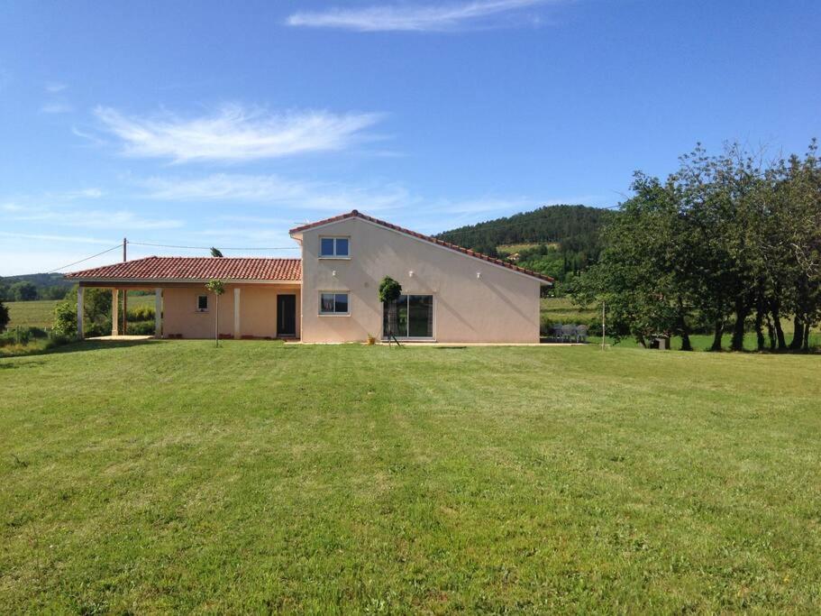 une maison avec une grande pelouse devant elle dans l'établissement Belle maison Vallée du Lot., à Prayssac