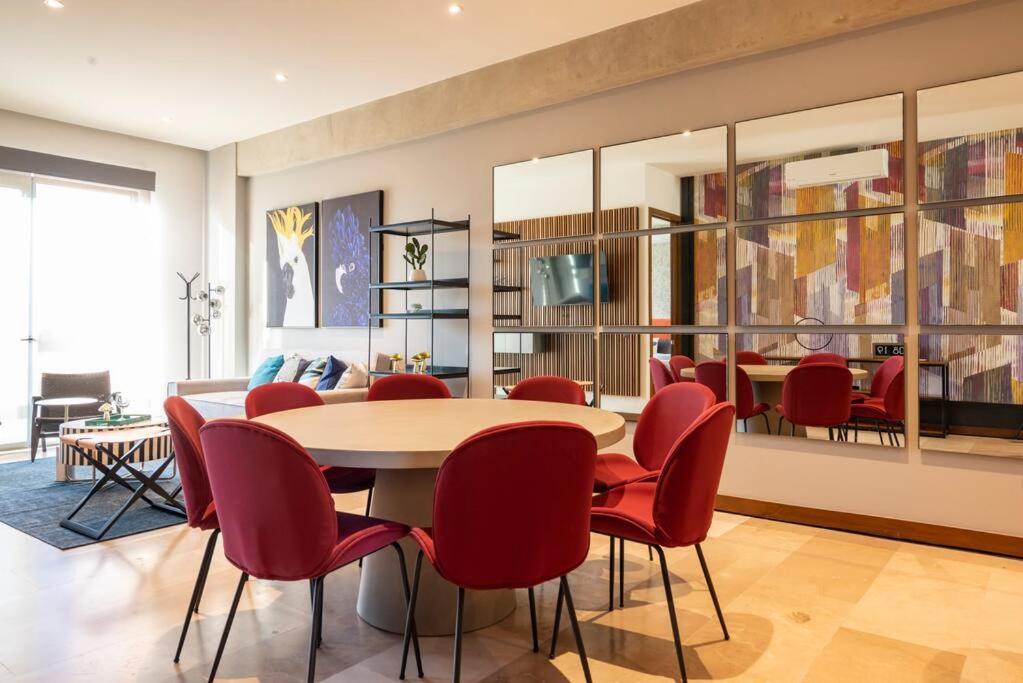 een eetkamer met een tafel en rode stoelen bij Amazing 2-bedrooms Condo in Guadalajara