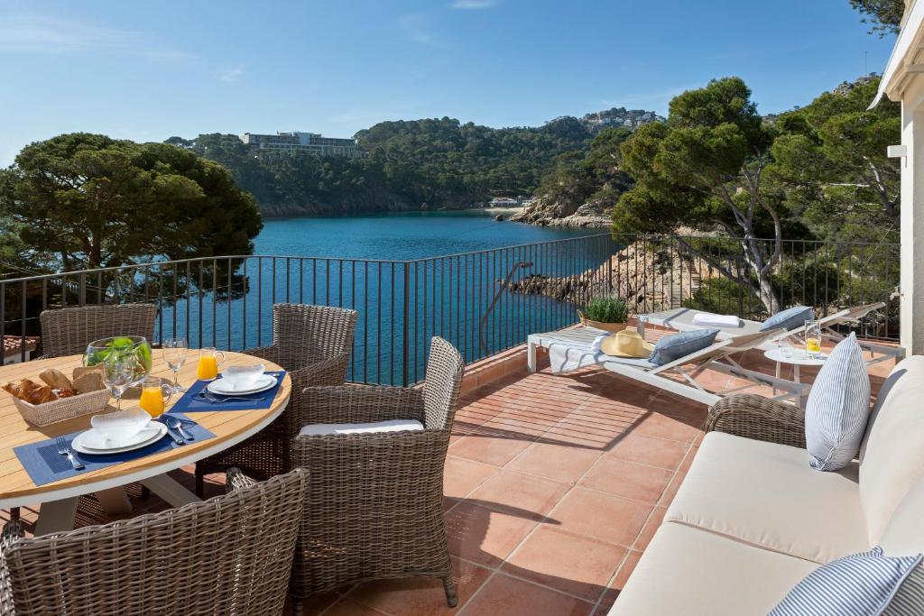 a patio with a table and chairs and a view of a river at Aiguablava Luxury Apartments in Begur