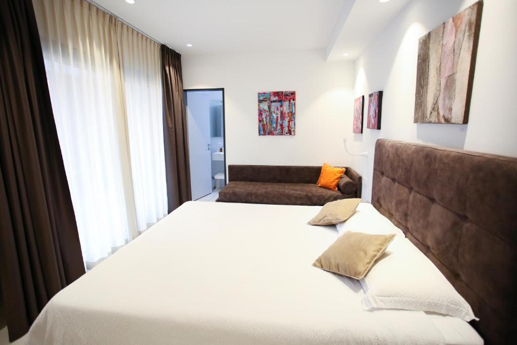 a bedroom with a large white bed and a window at Hotel Bellavista Locarno in Locarno