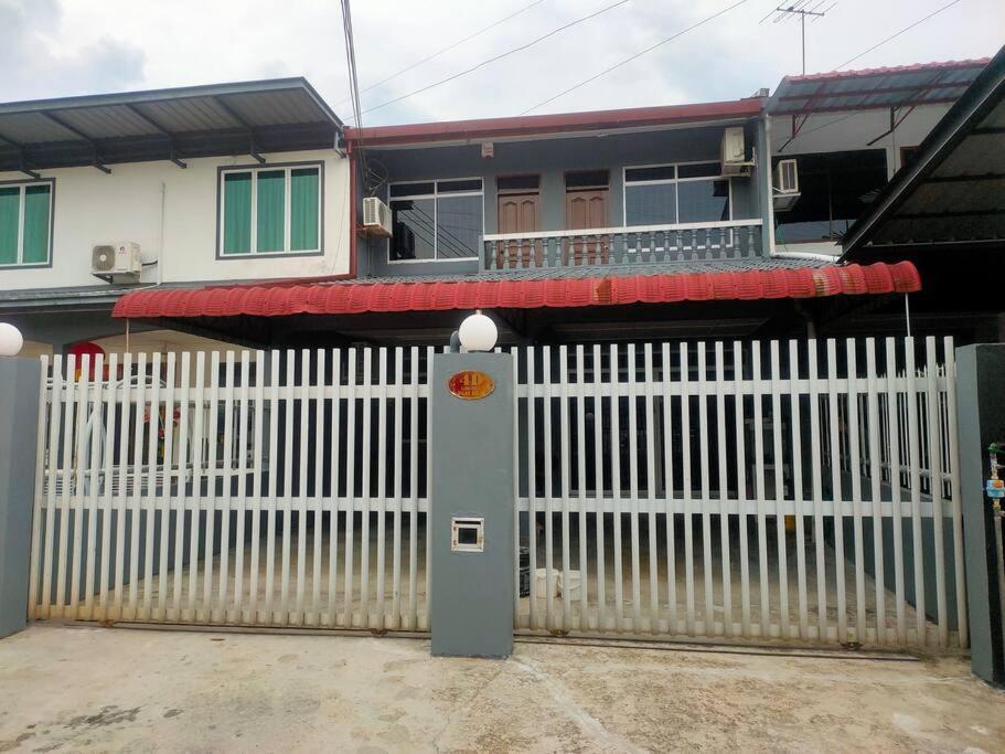a white fence in front of a house at Sibu kulas homestay in Sibu