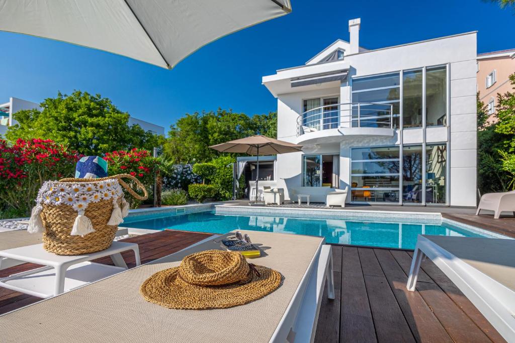 eine Villa mit Swimmingpool und ein Haus in der Unterkunft Villa CD in Dramalj