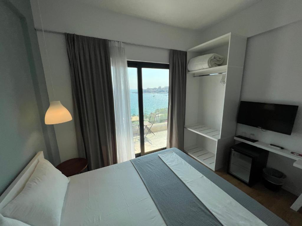 a hotel room with a bed and a view of the ocean at Kanes Bohemian Boutique Hotel in Sarandë