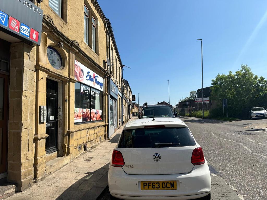 a white car parked on the side of a street at Stunning 1-Bed Studio in Pudsey in Pudsey