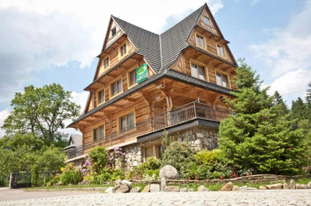 duży drewniany dom z czarnym dachem w obiekcie Willa Grań w mieście Kościelisko