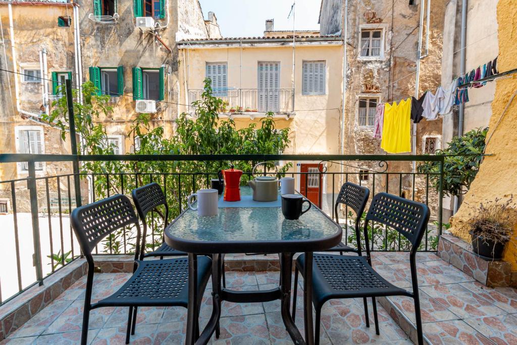 una mesa y sillas sentadas en un balcón en Cozy Corfiot house en Corfú