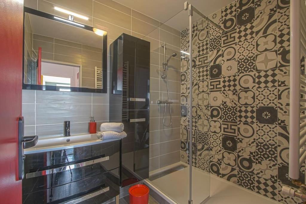 a bathroom with a glass shower with a sink at Appart 3 Chambres - 6 personnes - Mémorial - Université in Caen