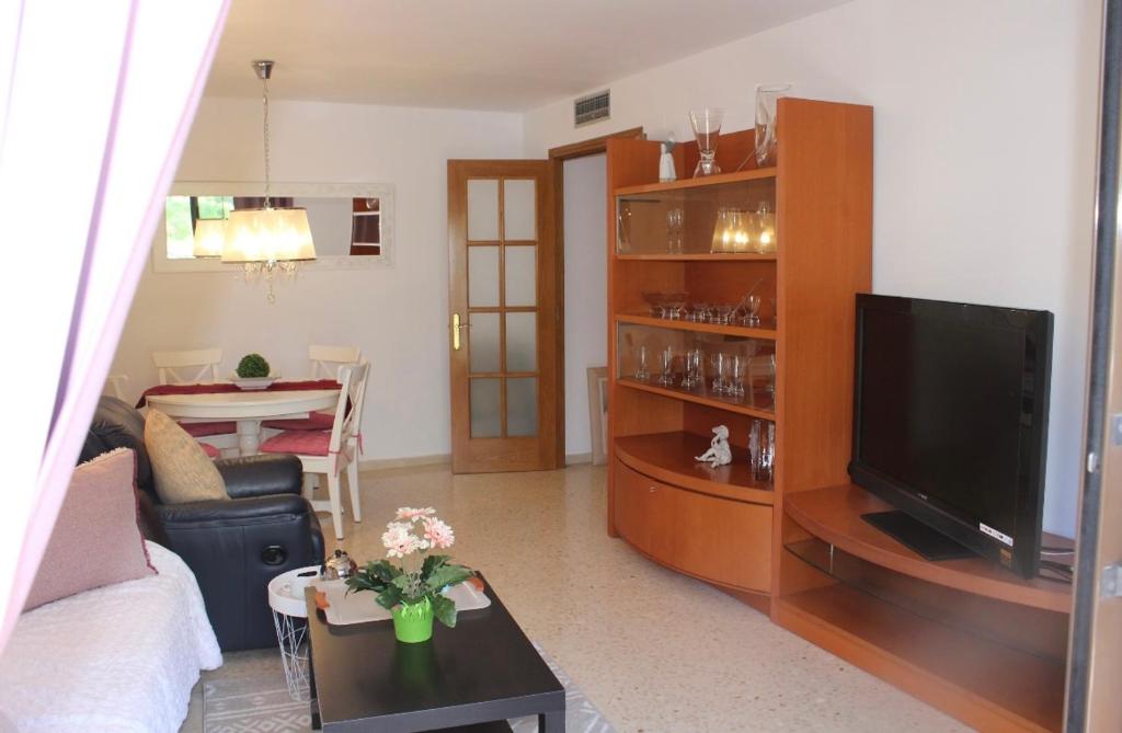 ein Wohnzimmer mit einem Flachbild-TV und einem Tisch in der Unterkunft Barcelo al riu in Monistrol de Montserrat